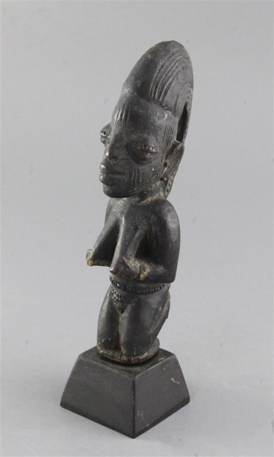 A Yoruba carved wood figure of a kneeling woman, 23cm, plus stand